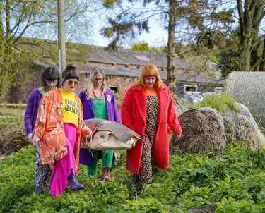 four young women carrying a body wrap in a shroud on a bowsprit and standing rigging