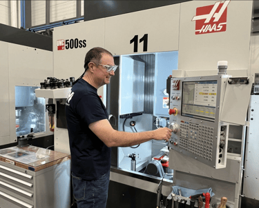 Photo is of a man working at a machine