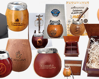 A collection of yerba mate gourd sets and bombilla straws in decorative gift boxes.
