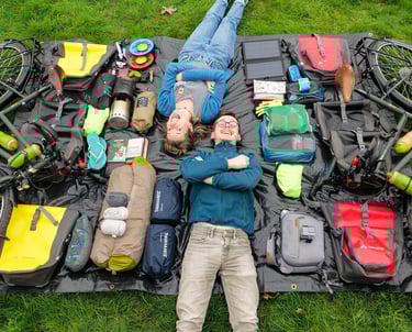 Couple d'aventuriers allongé avec tout leur matériel de voyage à vélo autour d'eux