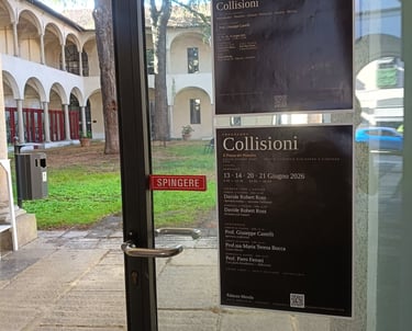Posters for the Collisioni art exhibition by Davide Robert Ross on a glass door overlooking a courtyard.