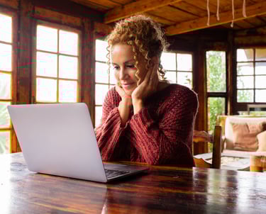 a woman sitting at a table with a laptop computer