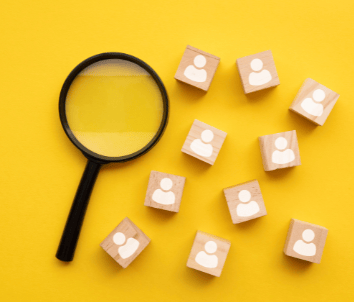 bir büyüteç ve üzerlerinde insan figürü olan tahta bloklar