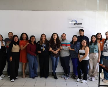 A group of diverse IEIPE education professionals smiling together in an office setting.