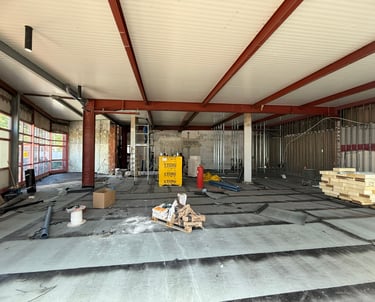 Rohbau-Innenraum mit Stahlträgern, Dämmmaterial und Vorbereitungen für den Innenausbau