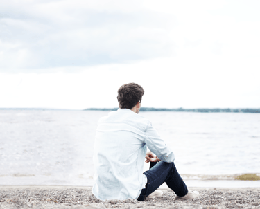 Young man sitting on the beach