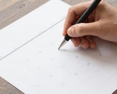 A focused individual working intently on a laptop surrounded by notes and sketches.