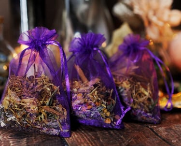 Three purple organza bags filled with herbs and flowers