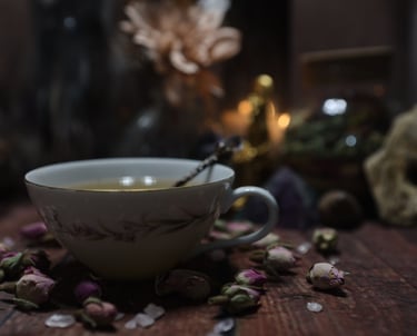 a cup of tea surrounded in dried pink roses