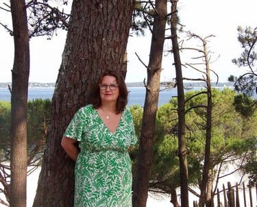 sophrologue spécialisée près des arbres face à la mer, reflétant une approche humaine