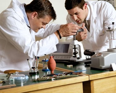 two men in lab coats working on a project