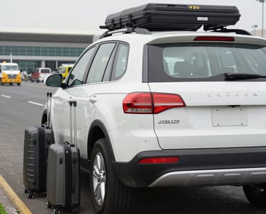 An airport shuttle bus labeled COBUS 3000 is parked on a tarmac area with two individuals wearing uniforms walking near it. The bus has visible branding for Shenzhen Baoan International Airport and features an orange roof with a small beacon light.