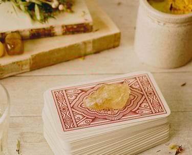 carta baralho cigano com pedra de cristal levemente amarelo e outras pedras e livros antigos a volt