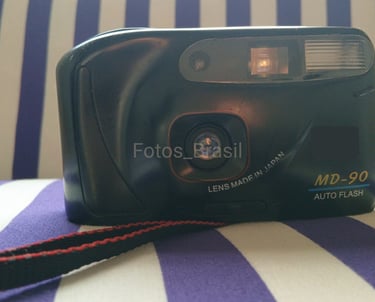 Sobre uma almofada está a majestosa, uma câmera fotográfica de filme do final dos anos 90