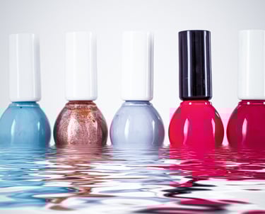 a group of five different colored nail polishes