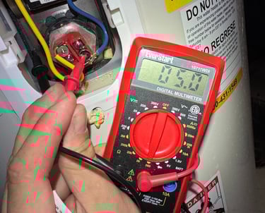 A technician uses a digital multimeter to test a water heater heating element for electrical continuity.