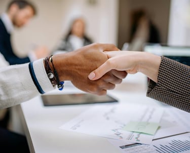 a man and woman shaking hands in a meeting room