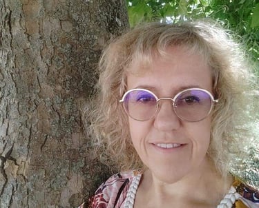 a woman with glasses and a pearl necklace