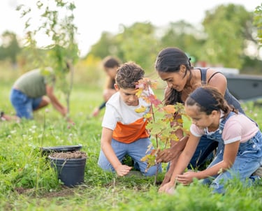 Enfants et adultes plantant un arbre en souvenir d’une personne décédée.