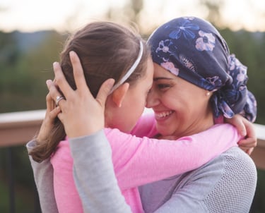 Mother in purple head scarf embraces daughter - holistic medicine for cancer Roaring Fork Valley CO
