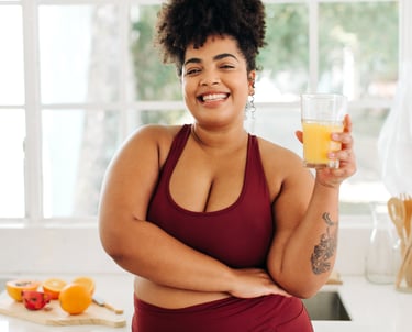 Woman in red tank top drinks juice happily after her holistic medicine treatment Carbondale, CO