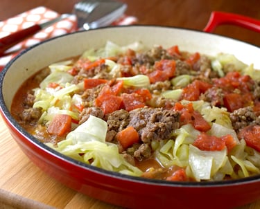 a bowl of cabbage, beef, and tomatoes