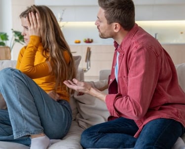 a man and woman sitting on a couch in a living room
