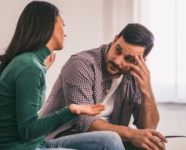 a man and woman sitting on a couch in a living room