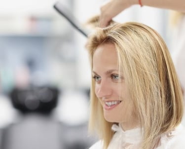 a woman is getting her hair cut by a hairdressuck