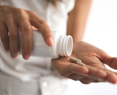 a woman holding a pill bottle