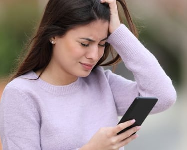 a woman in a purple sweater holding a cell phone