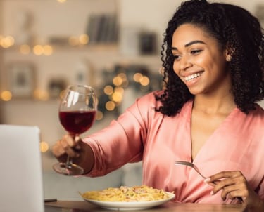 a woman sitting at a table with a glass of wine