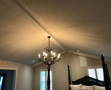 Bedroom ceiling with faux beams a chandelier and recessed lighting