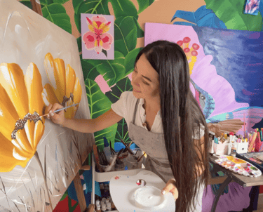 Artista plástica pintando lienzo decorativo a mano, técnica mixta en acrílico con texturas modernas 