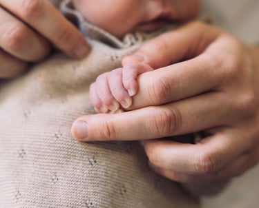 Photographe naissance Paris 8 : gros plan mains maman et bébé