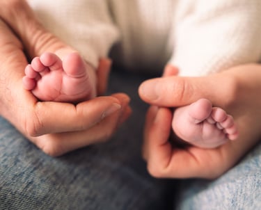 Photographe nouveau-né Paris 12 : mains des parents tenant les pieds.