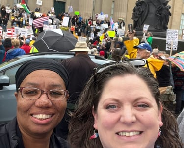 Two women standing in front of large protest group