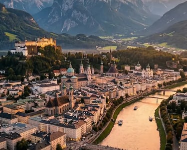Aerial view of Salzburg old town at sunset with Alpine mountains in the background