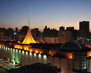 a city skyline at night time with a church and a church steeple