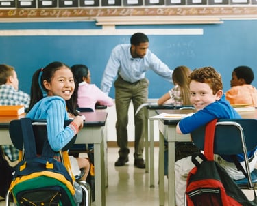 a man standing in front of a classroom with a group of children
