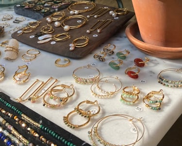 a table with a lot of jewelry and a potted plant