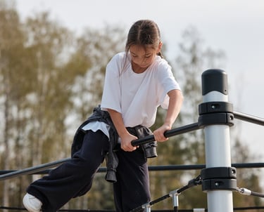 Fille grimpant sur une structure Kenguru Pro Kids Active Play en extérieur.