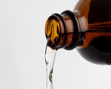 a brown bottle with clear liquid pouring out