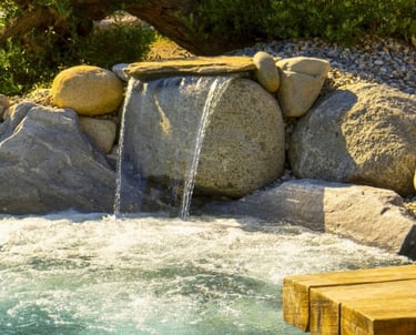 Dettaglio piscina con rocce, sabbia naturale e acqua cristallina