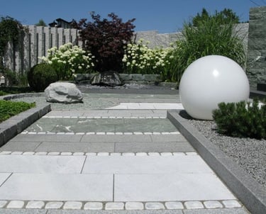 viale con pavimentazione in cemento e aiuole con piante aromatiche