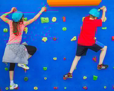 Niños en un rocódromo escalando