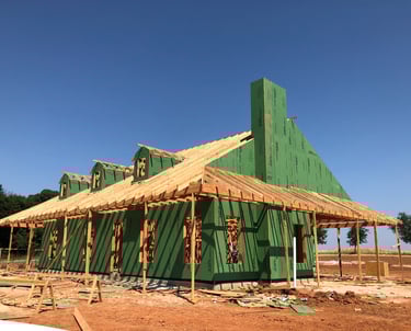 a house being built with green siding and wood framing