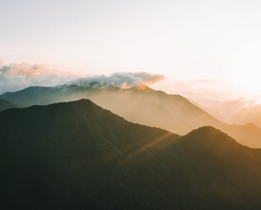 a mountain scene with the sun rising
