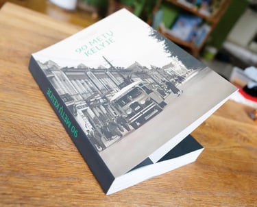Book cover. The cover shows a vintage bus driving down Laisvės Alėja. 