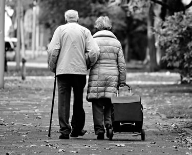 Couple growing old together walking arm-in-arm. 